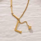 ALEXIA - Collar con inicial personalizada y dije de dado en baño de oro™